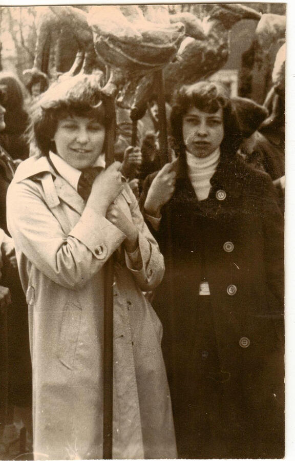 Renata (right) holding paper sculptures on sticks used in festivals standing beside her fellow art school student (right)